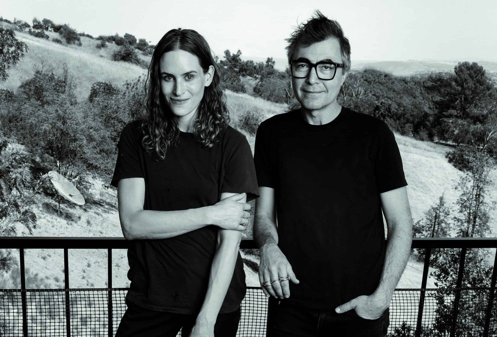 A black and white photo of a man and woman standing next to each other, showcasing their evident desire.