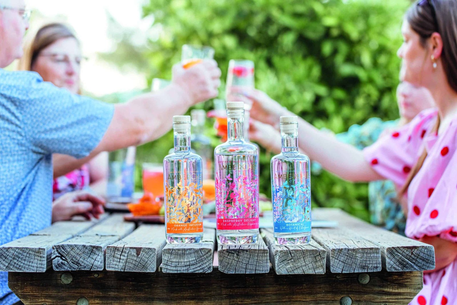A family toasting at a table with bottles of gin.
