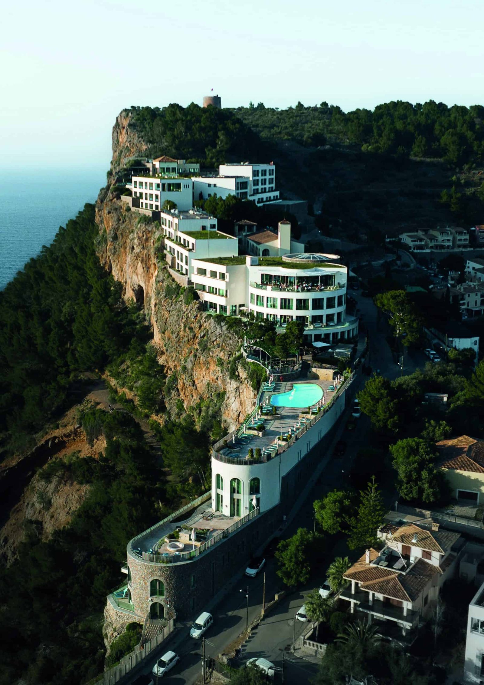 An idyllic hotel on an island cliff overlooking the ocean.