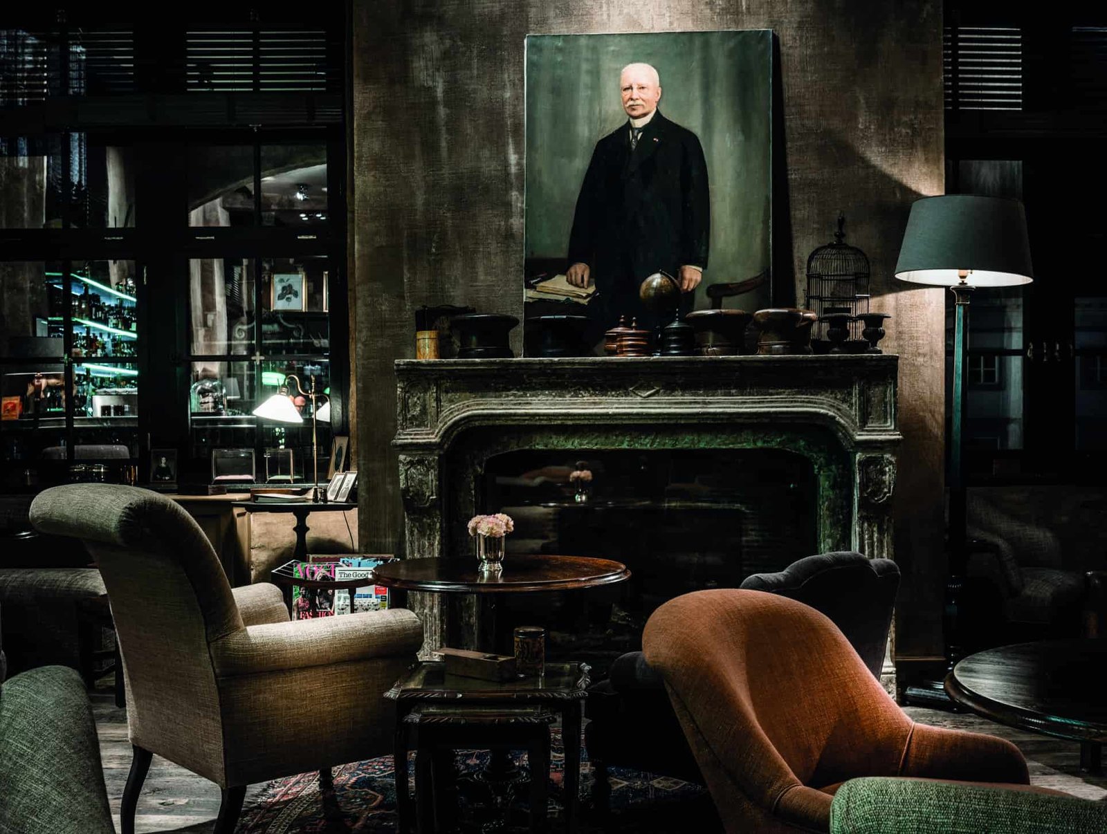 A luxury room delivering coziness and comfort, complete with a fireplace, chairs, and a painting.