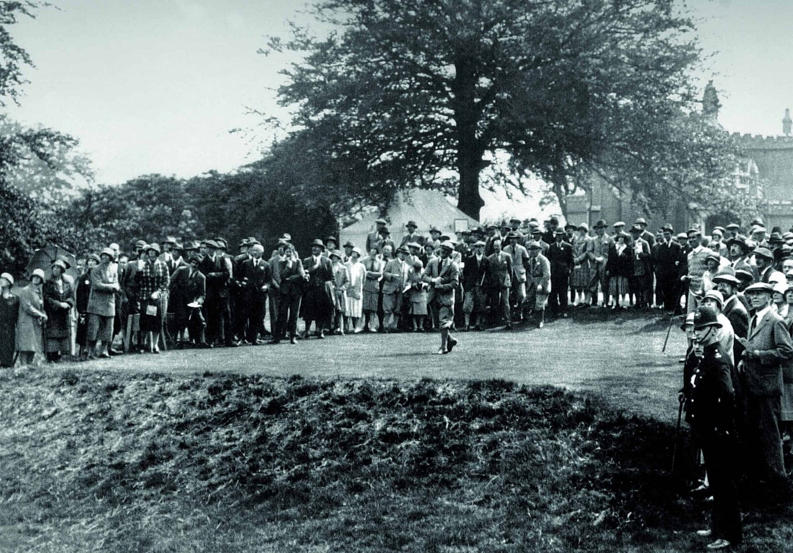 A crowd of people watching a home golfer.