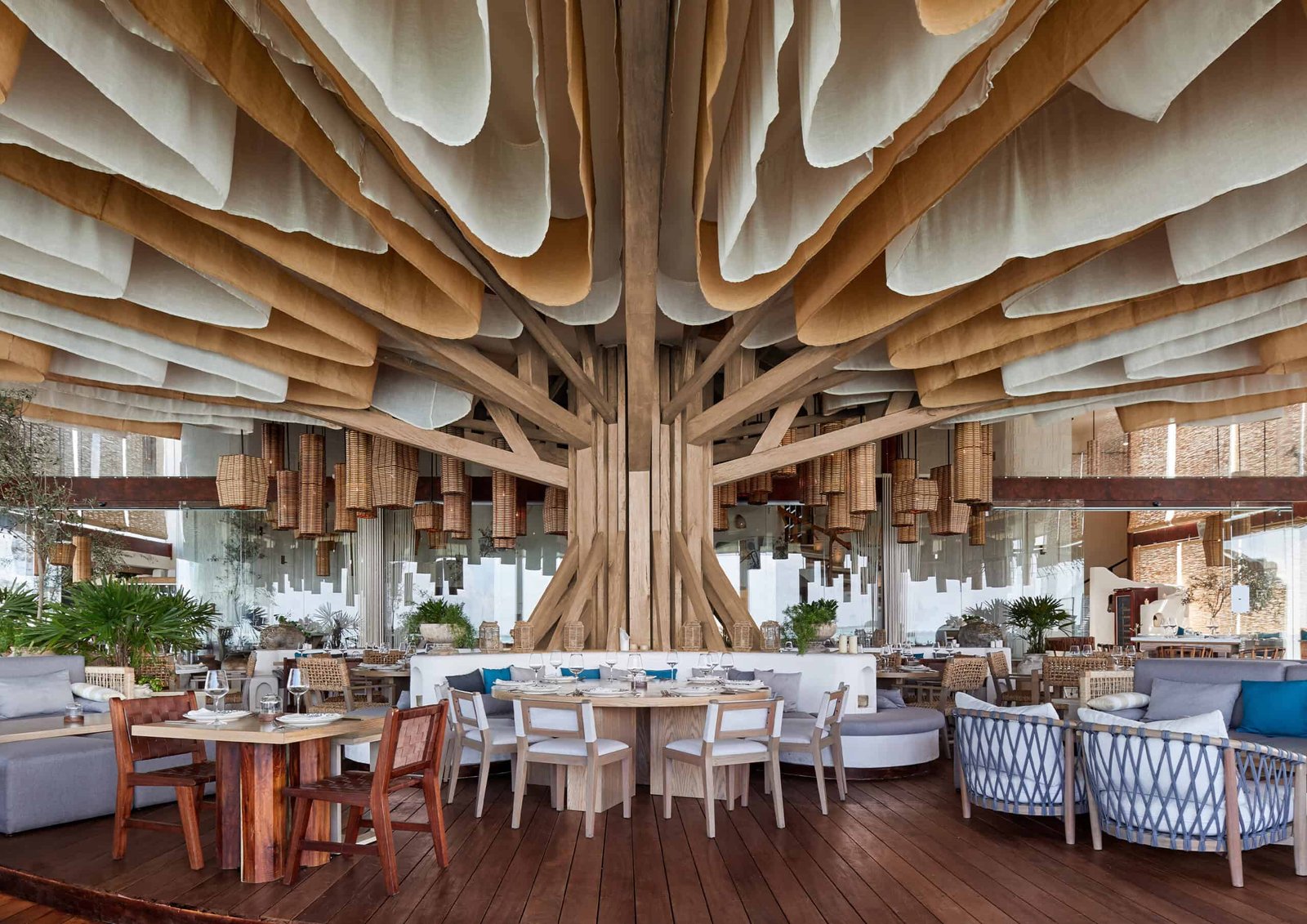 A sensory-oriented restaurant that incorporates a tree as a focal point in its interior design.