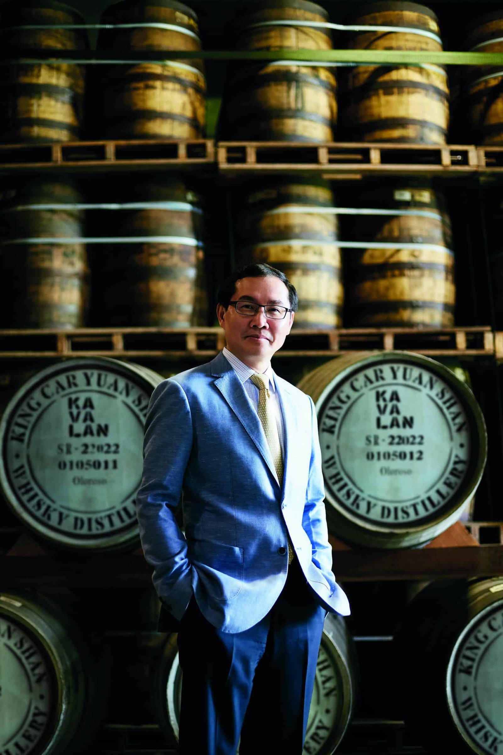 A man in a suit standing in front of barrels during the first Taiwan trade fair.
