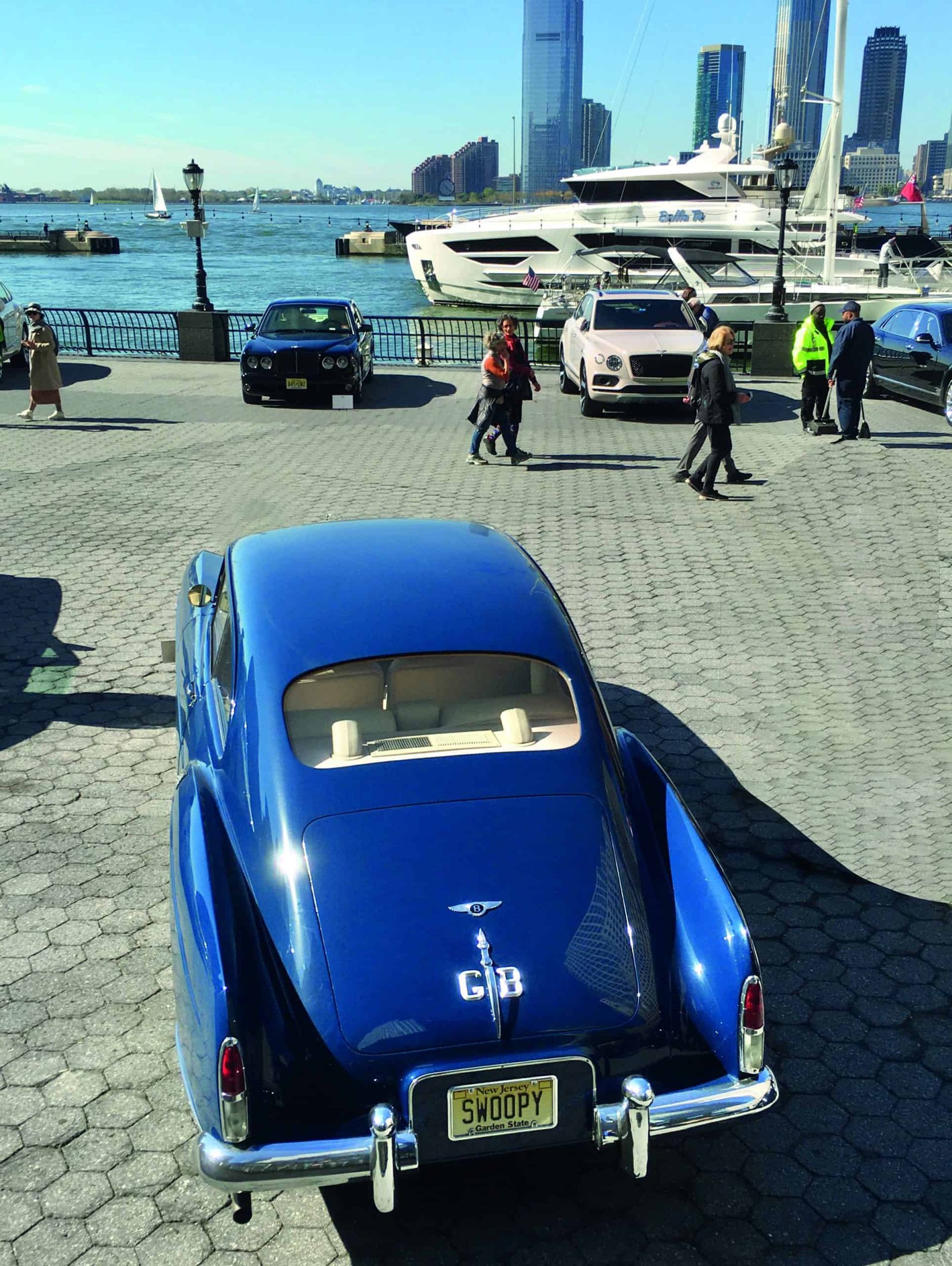 A blue car is parked in front of a building, an endless experiment.