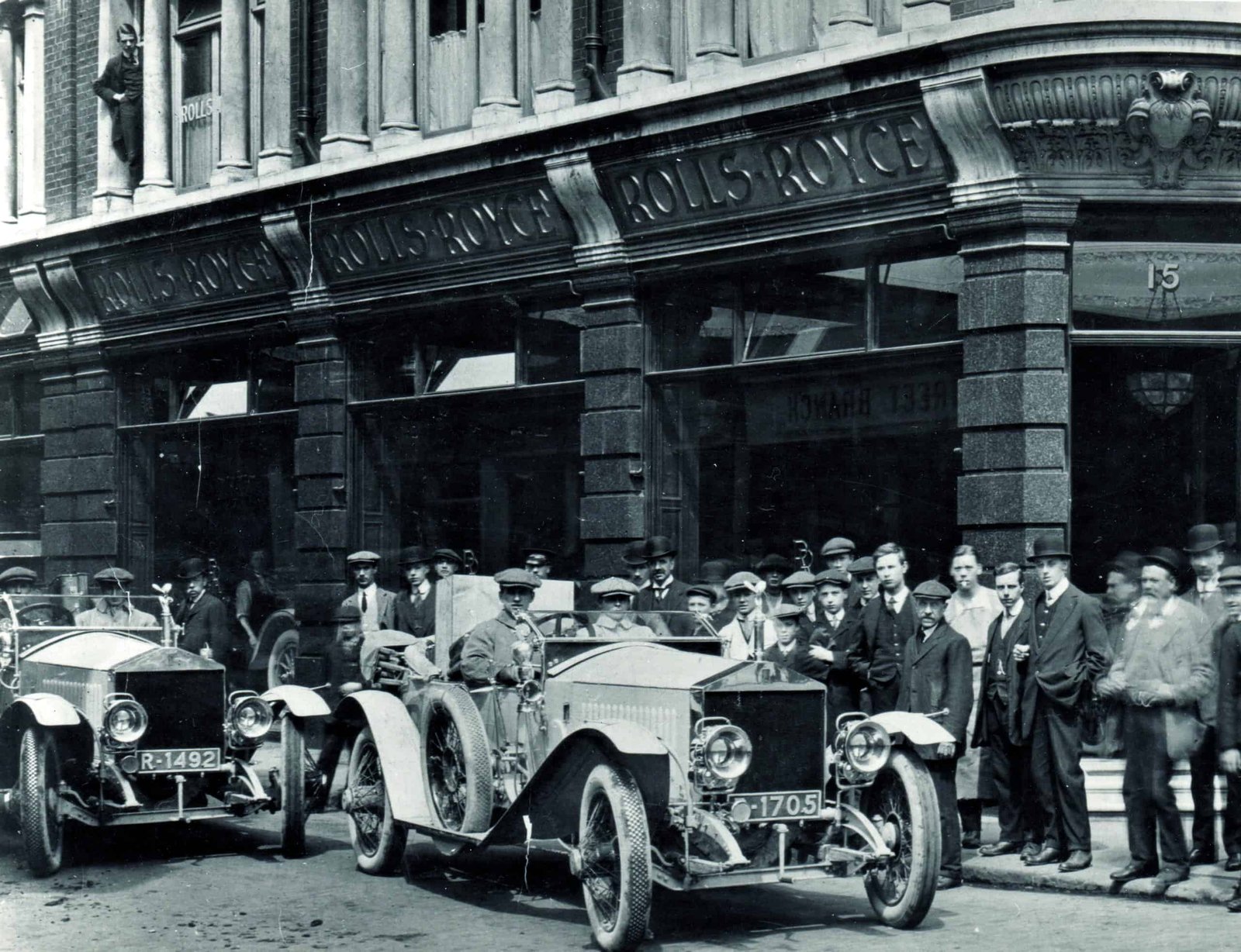 A century-old group of people standing in front of a landmark building.