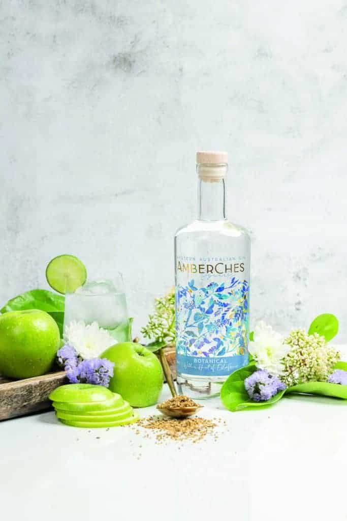 A bottle of gin and flowers on a table, creating a serene atmosphere for a family gathering.