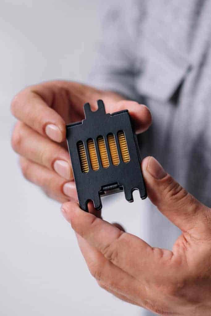 A person's hands breaking a small black device.