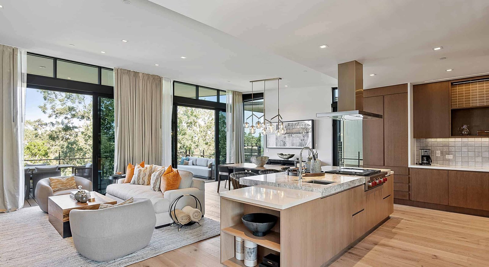 An open kitchen and living room with beautiful large windows.
