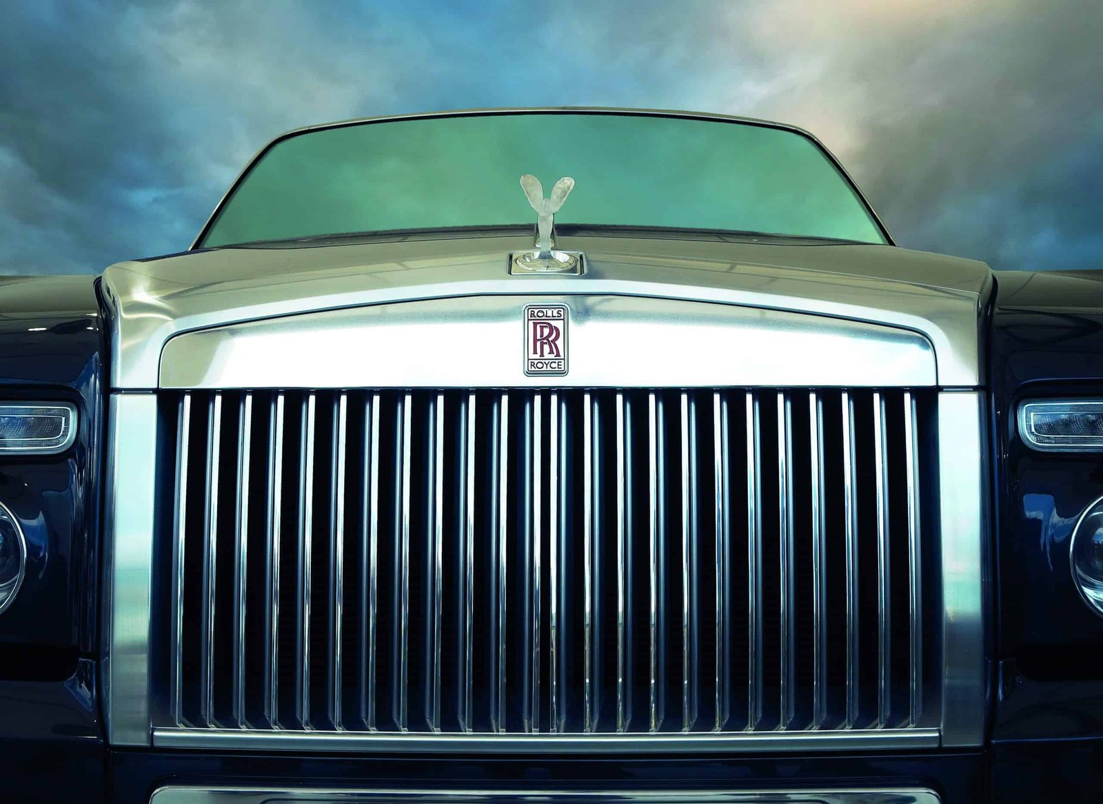 A splendid image of a Rolls Royce soaring gracefully beneath a breathtaking cloudy sky.