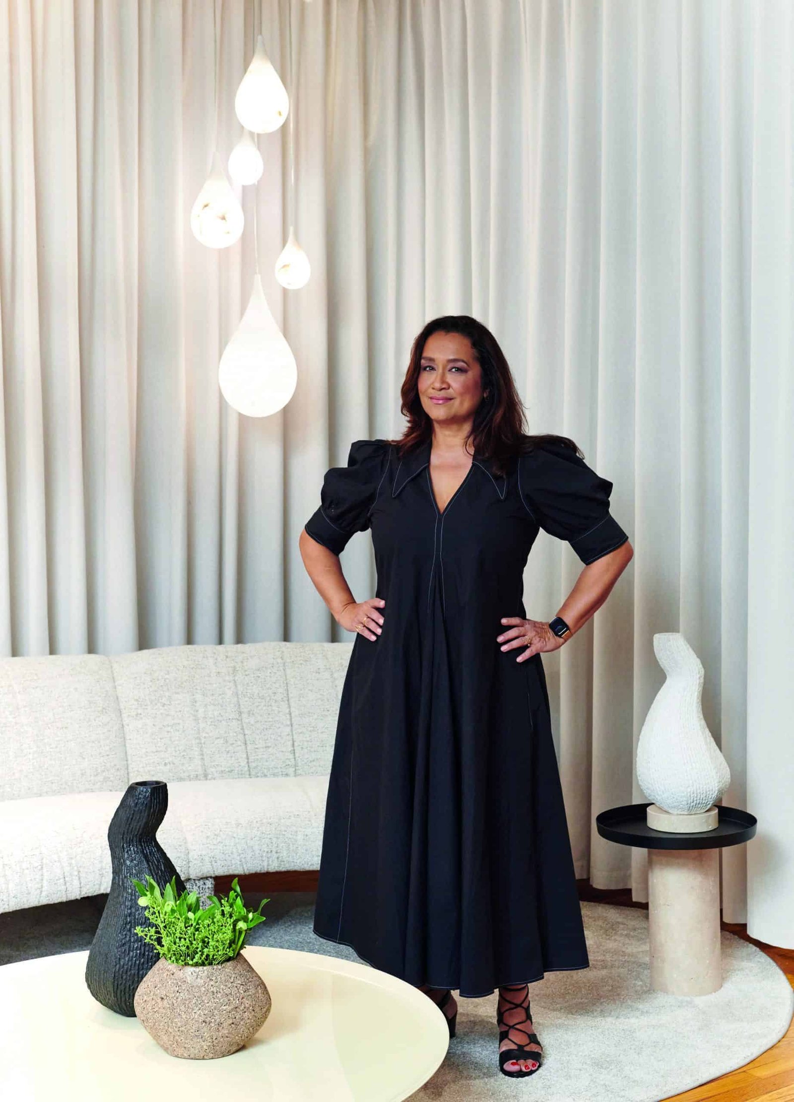 A woman in a black dress creating harmony in a living room.