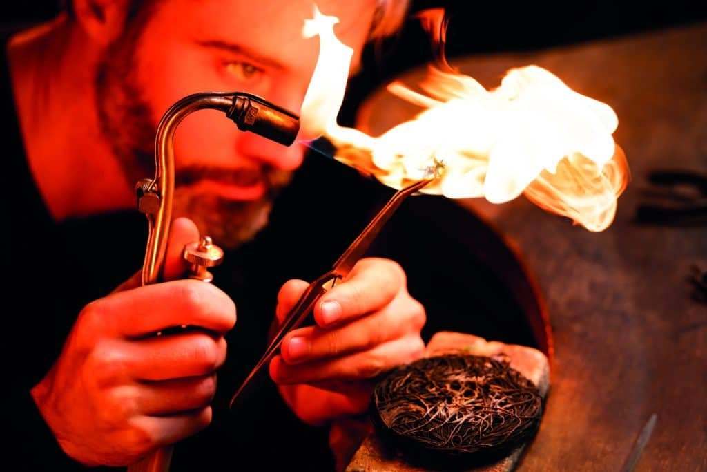A man with a beard experiencing a life moment while working with a torch.