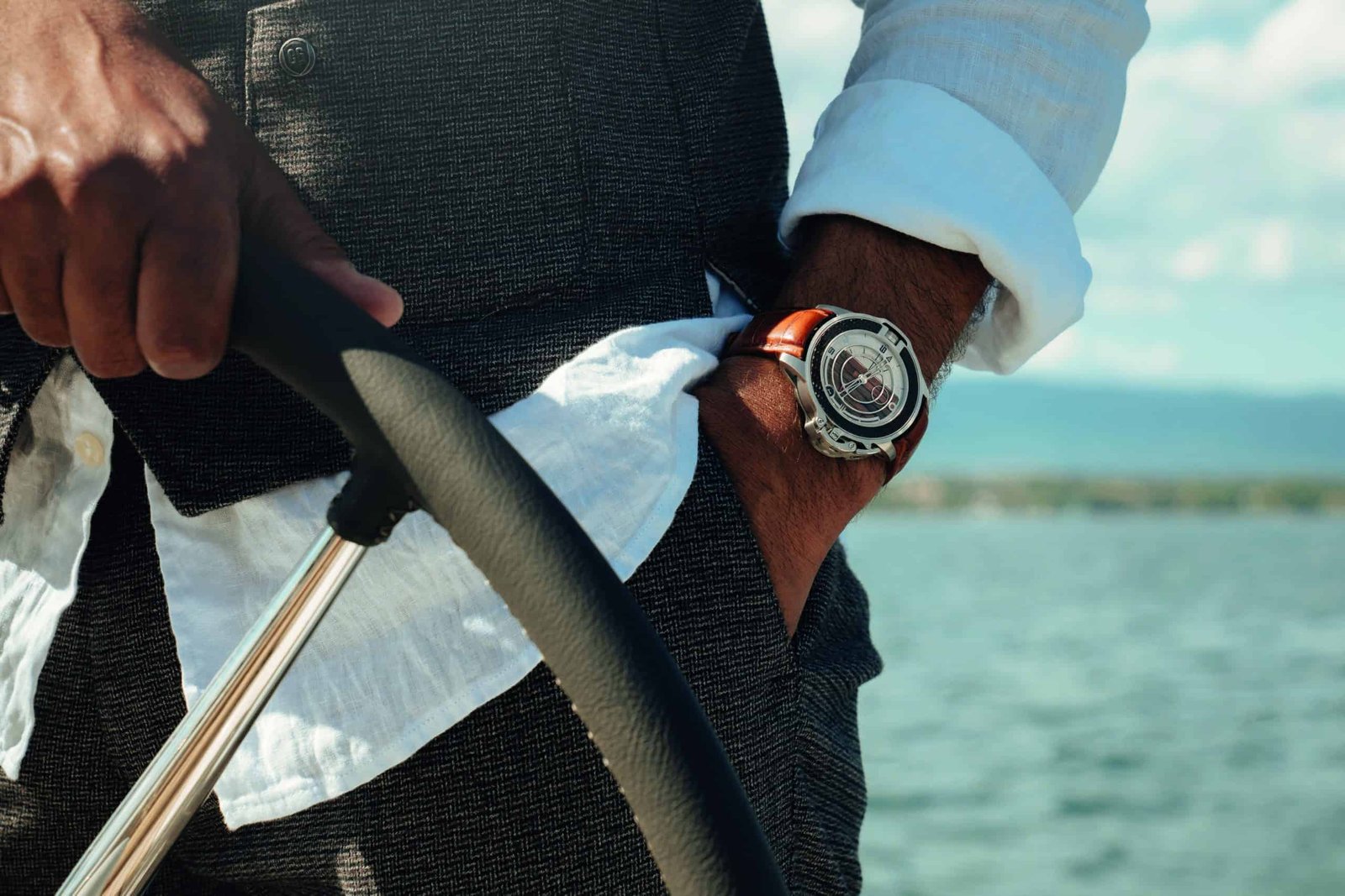 A man wearing a watch while setting sail on a boat.