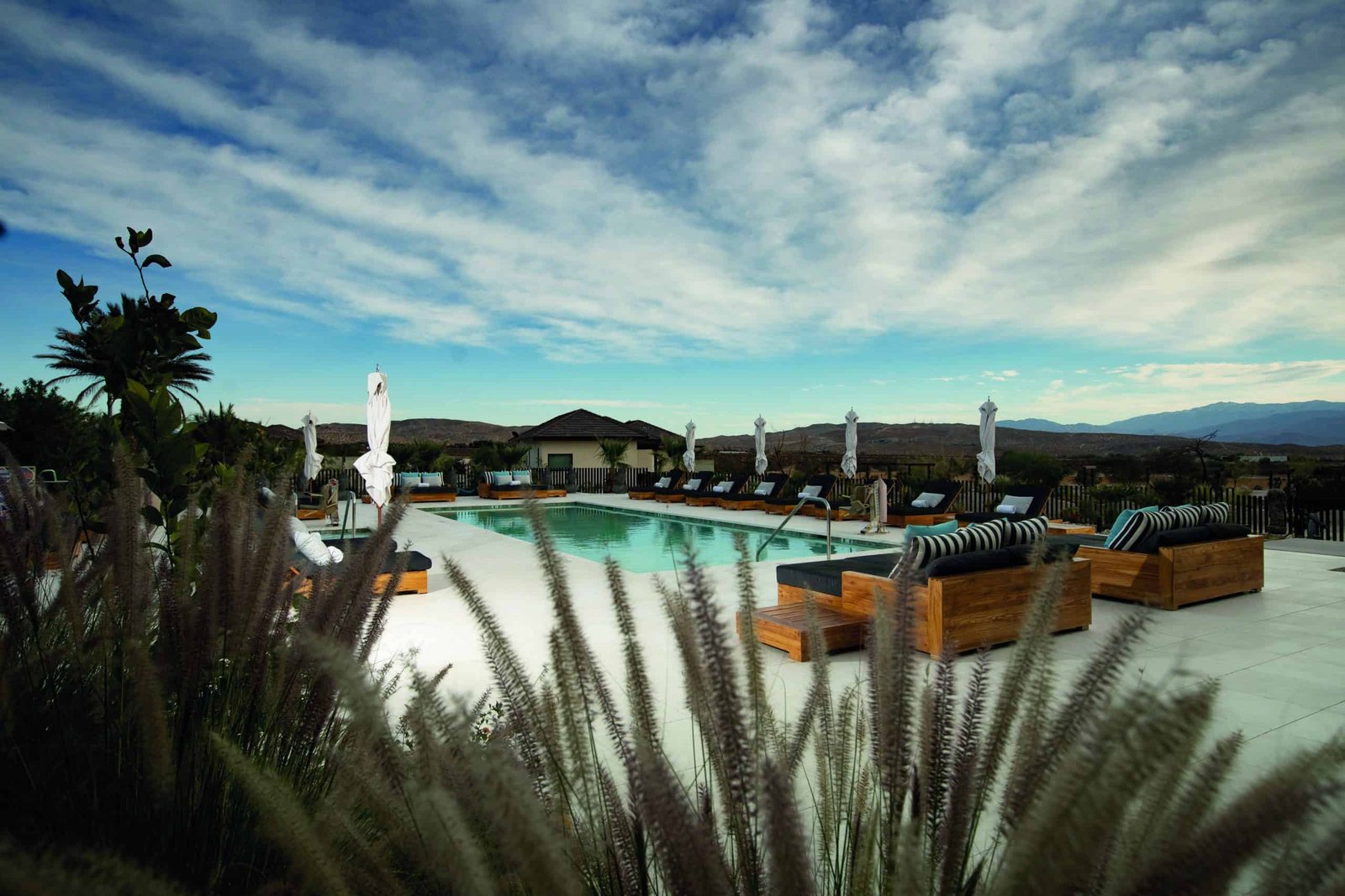A wellness oasis, featuring a swimming pool nestled in the middle of a serene grassy area.