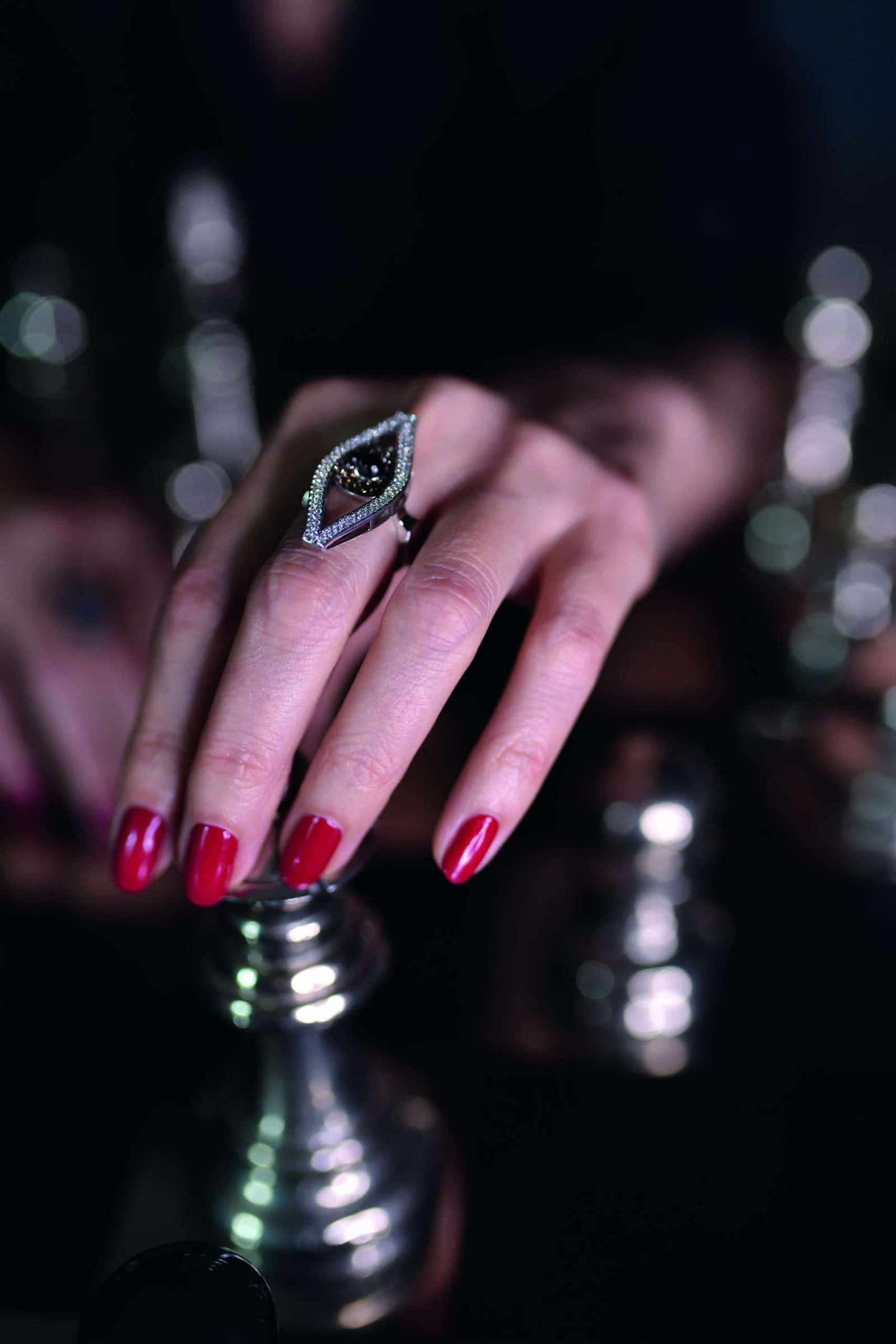 An elegant woman's hand delicately holding a ring on a chess board, creating a captivating symbol.