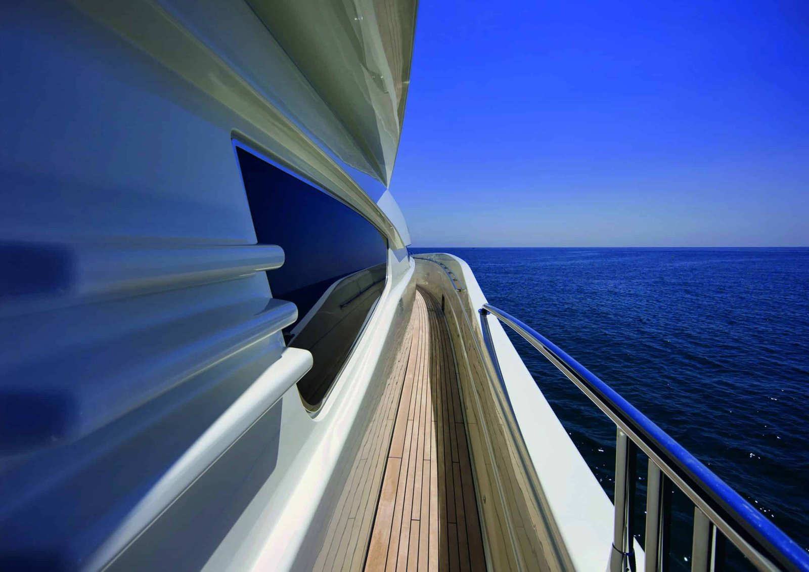 A white railing on the side of a boat gently sways with the turning tide.