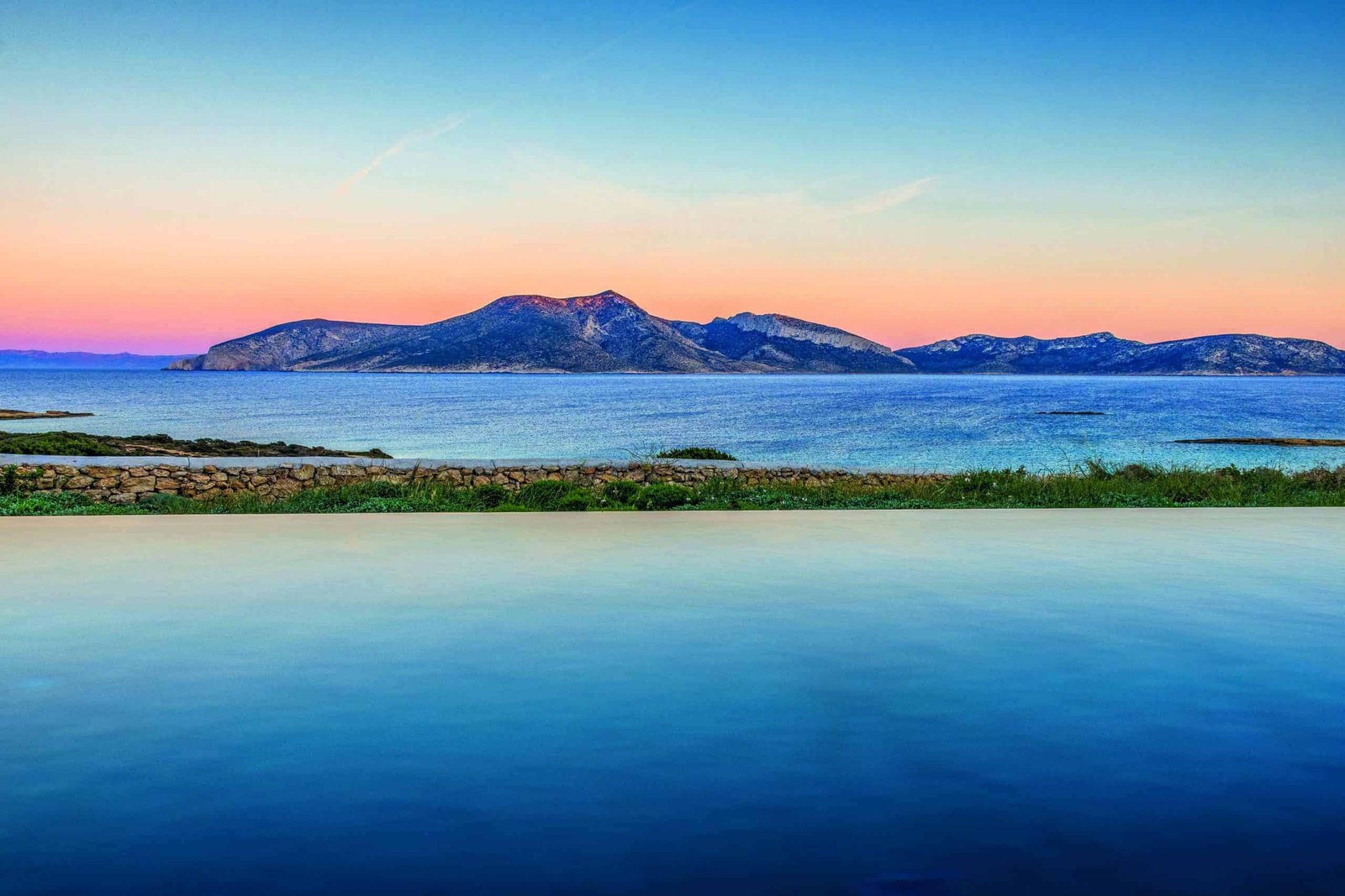A magical pool with a view of the ocean and mountains.