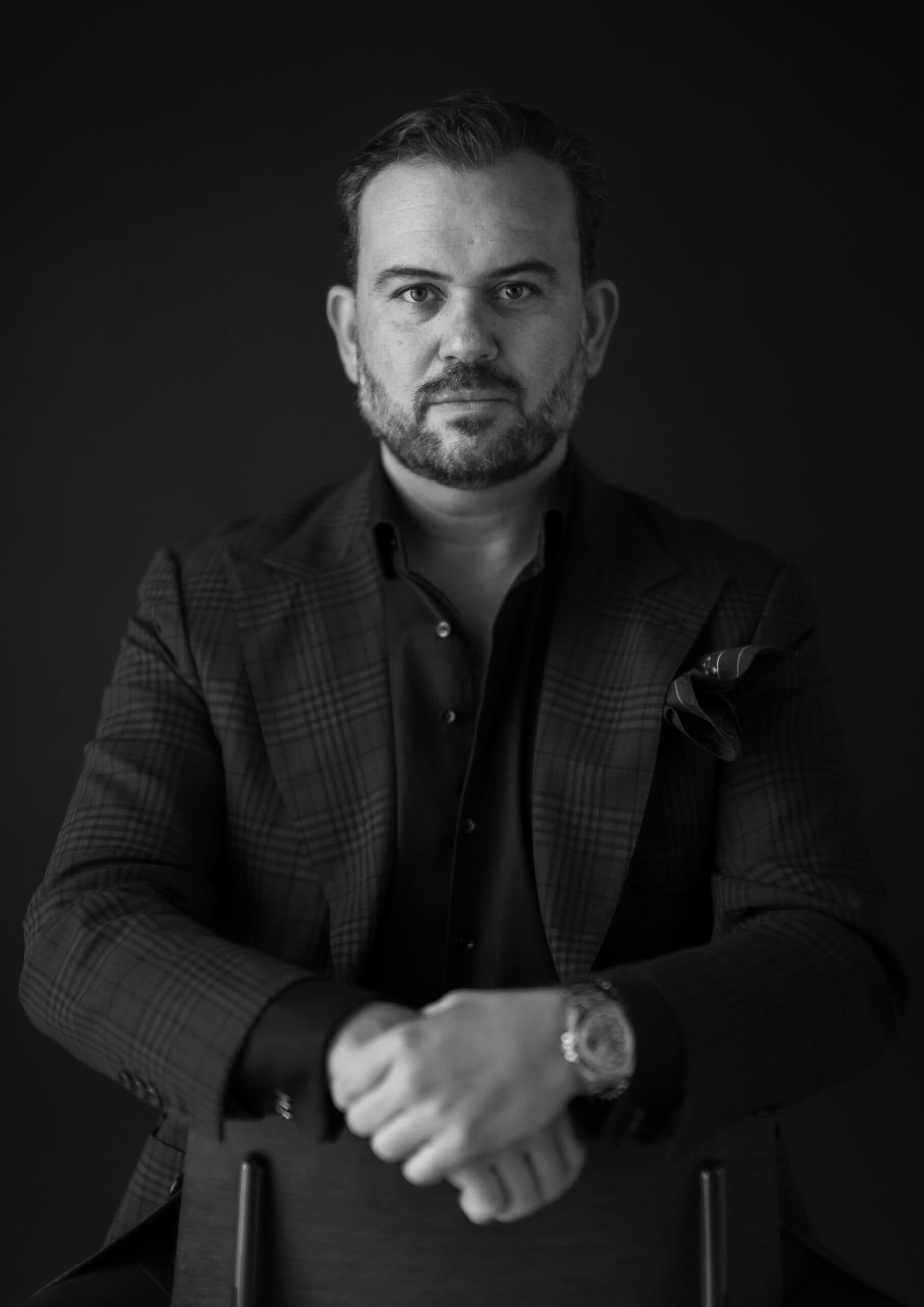 A man sitting on a chair captured in a black and white photo, showcasing the art of sensory design.