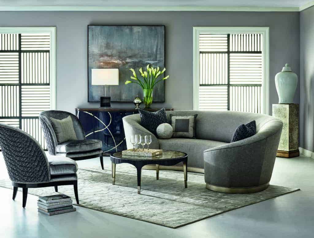 A living room with a luxury grey couch and chairs.
