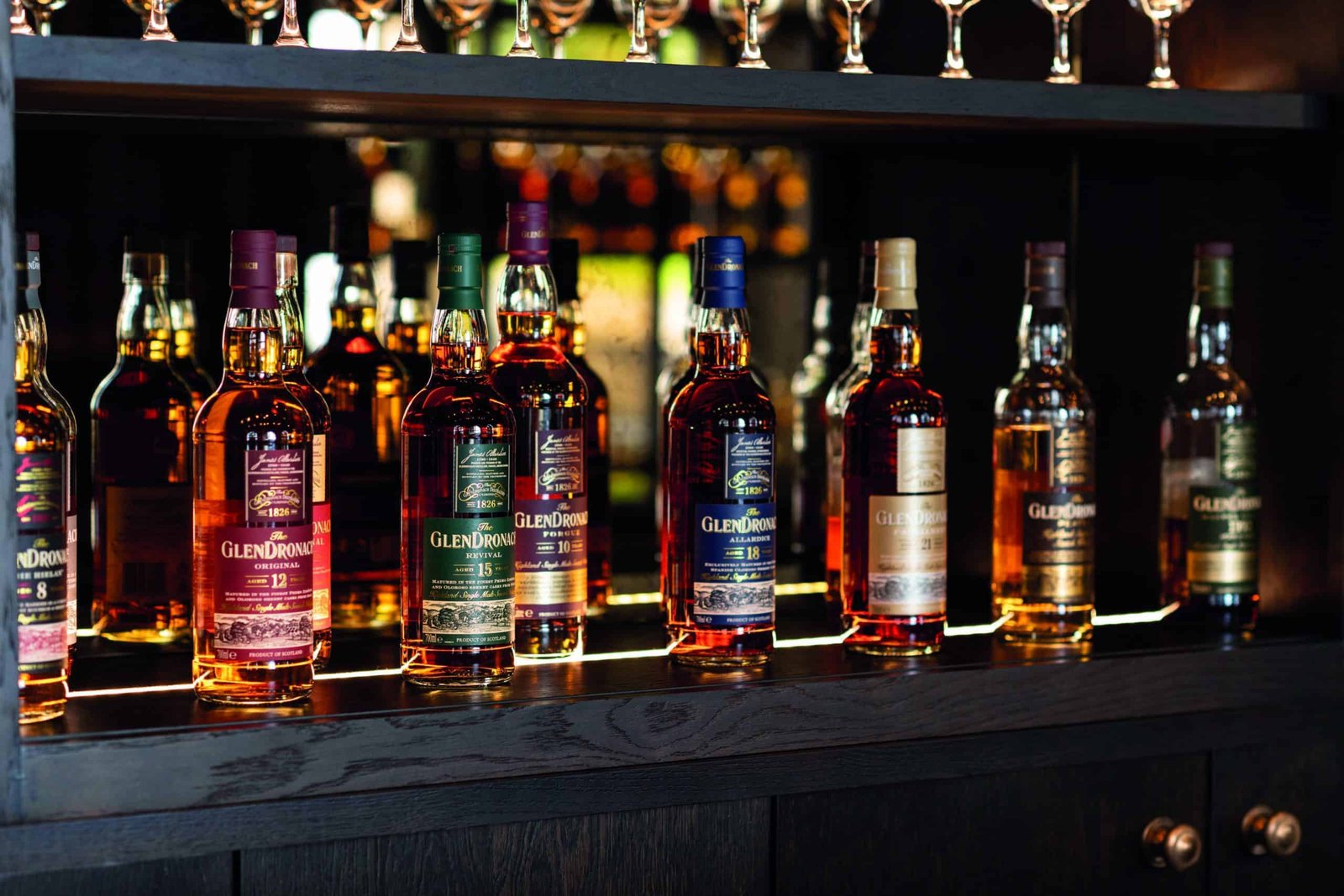 A row of Sherried whisky bottles on a shelf.
