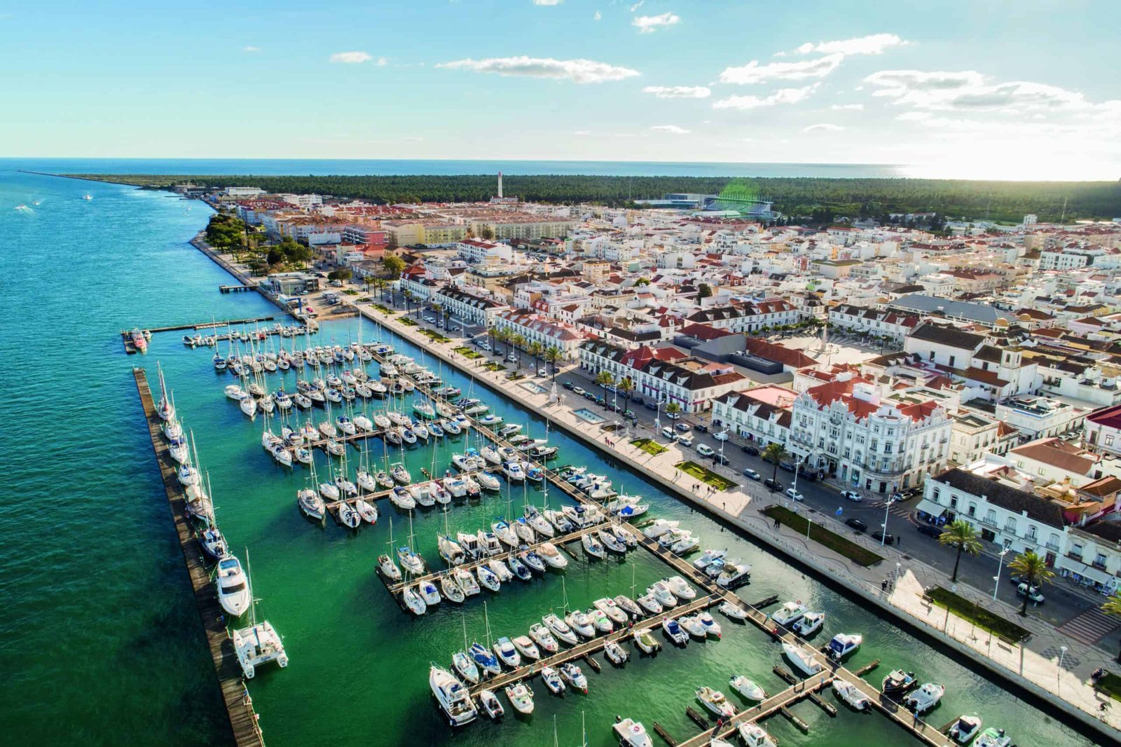 A grand style aerial view of a city with boats docked in the harbor.