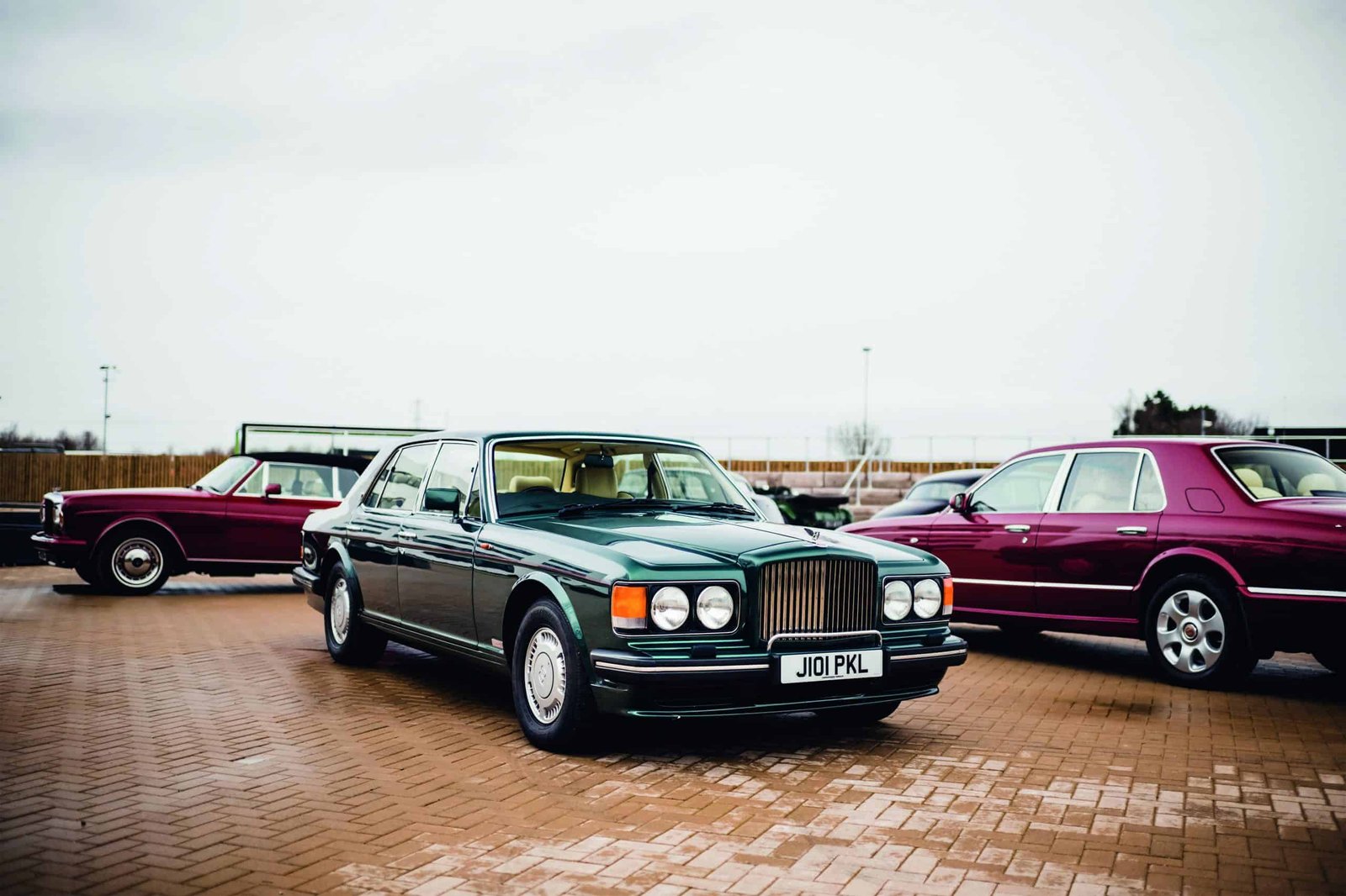 A group of bentley cars parked in a parking lot.