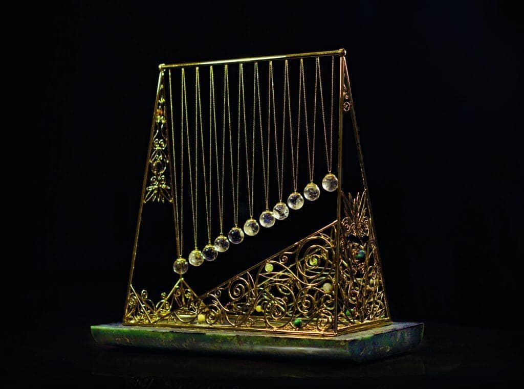A bejewelled gold harp on a black background, effortlessly balancing in harmony.