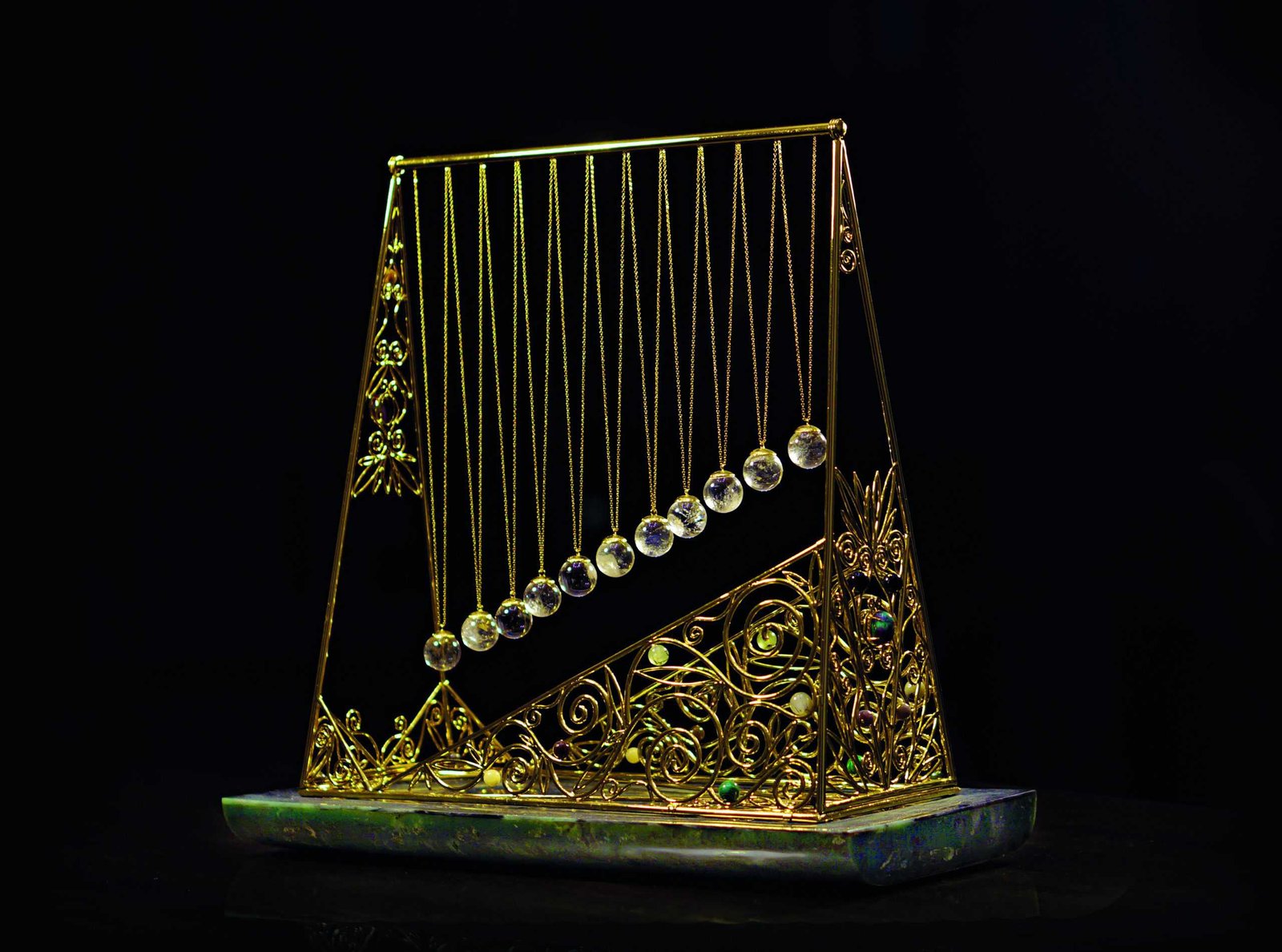 A bejewelled gold harp on a black background, effortlessly balancing in harmony.