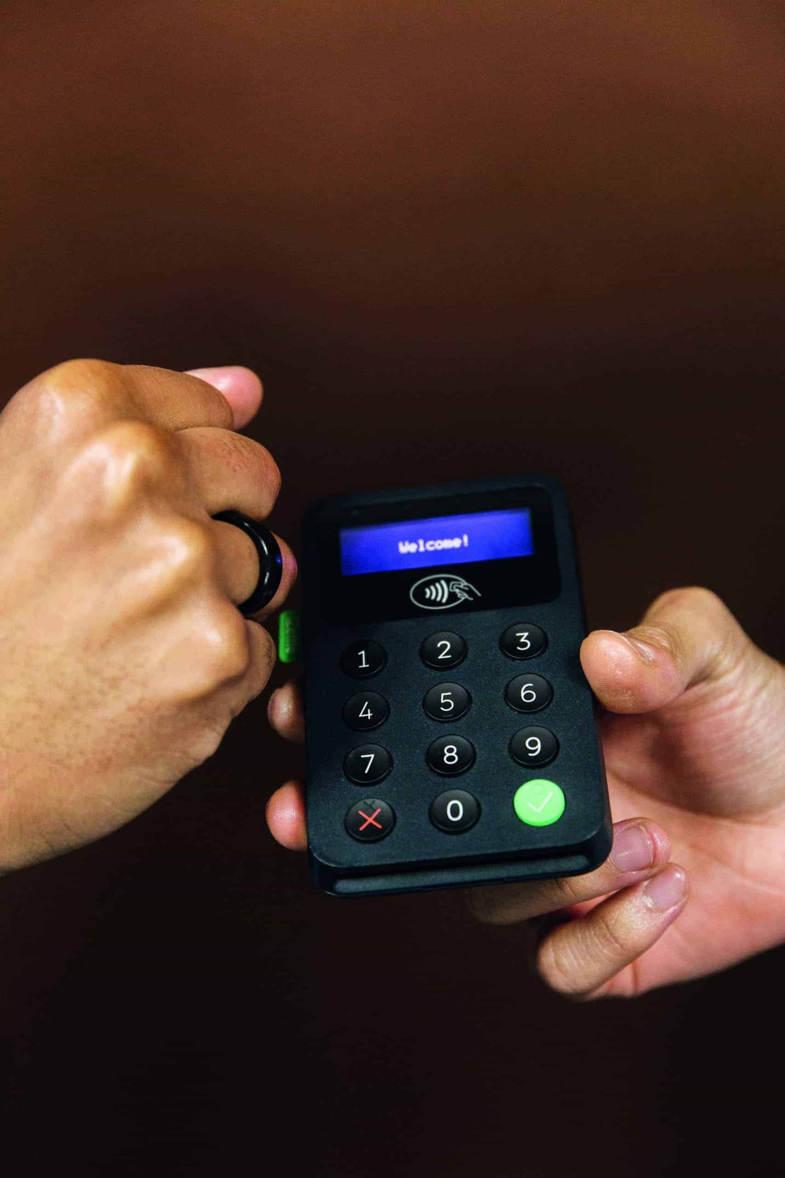 A person is holding a credit card while another person holds a debit card.