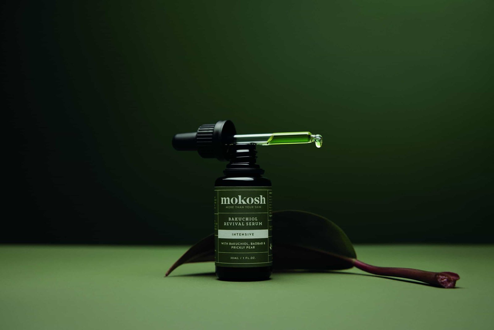 A bottle of super naturals cbd oil on a green background.