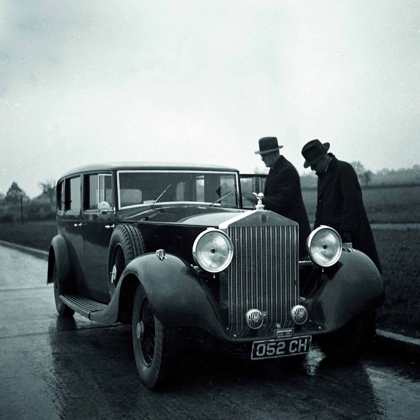 Two men standing next to a car in the rain, demonstrating bold innovation.