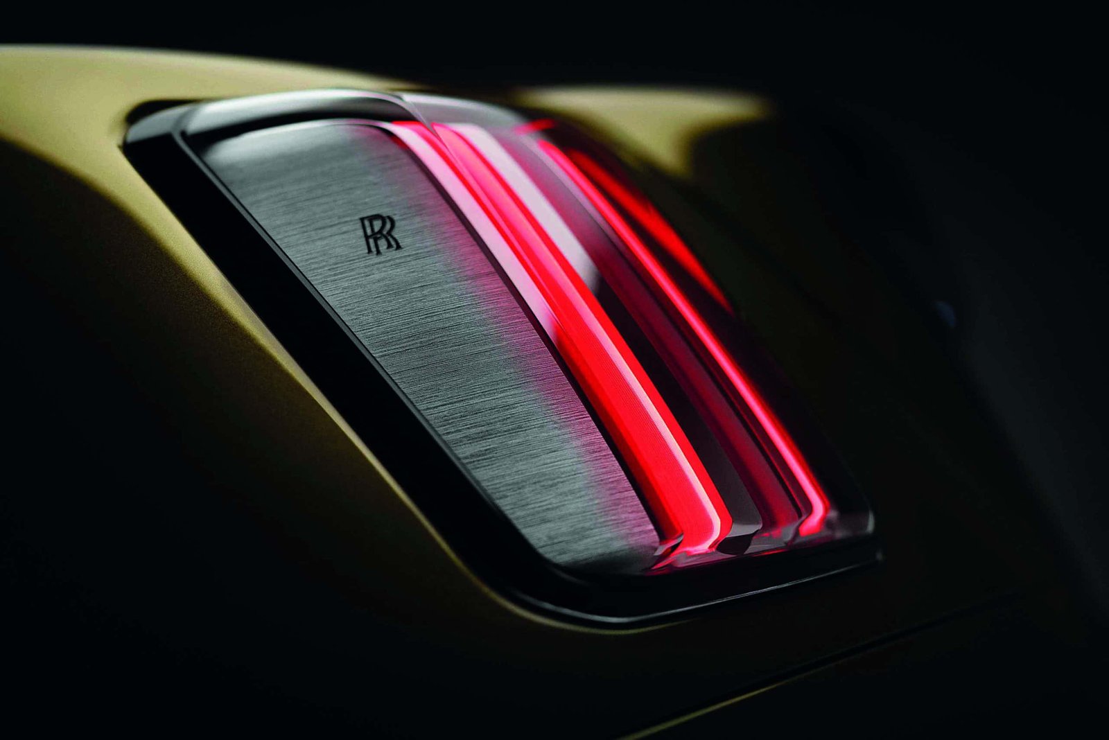 A close up of the rear light of a yellow car with a Spectre effect.