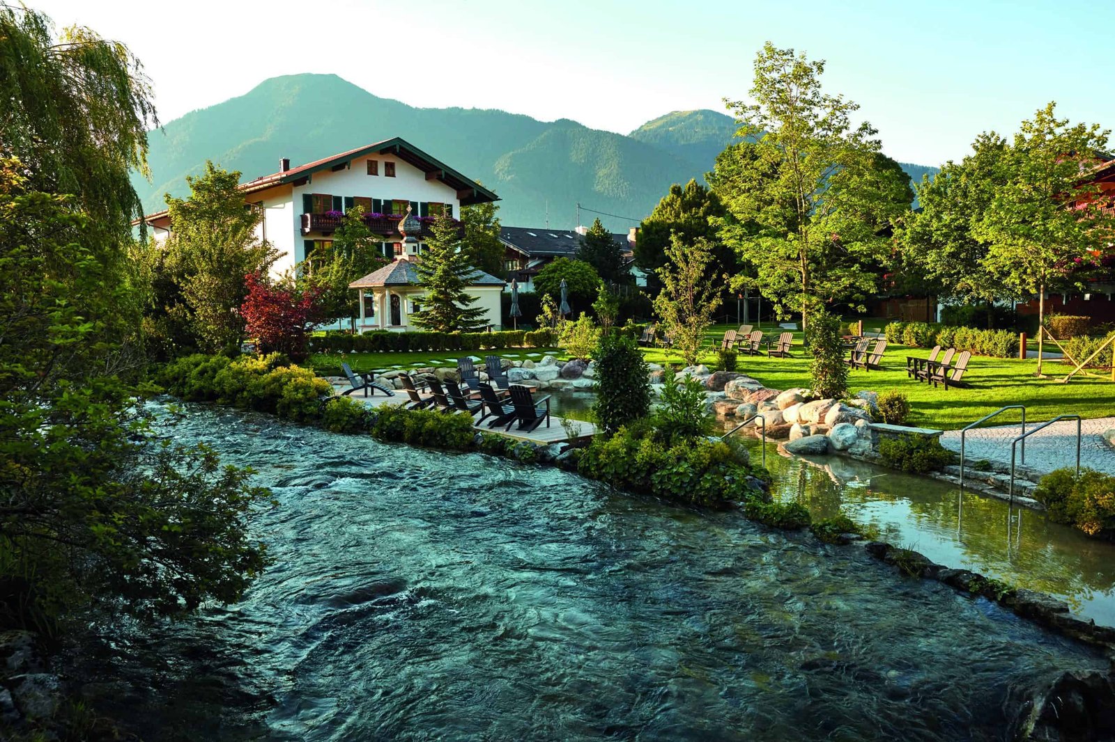 A small stream meandering through a serene grassy area.