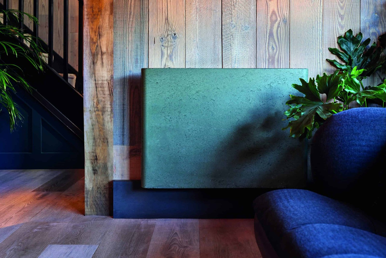 A blue couch impression in front of a wooden wall, boosting SEO.