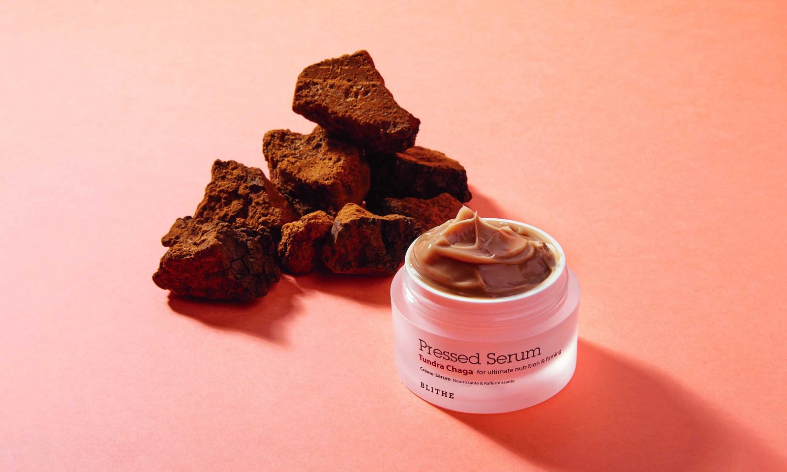 A delightful jar of chocolate cream on a pink background.