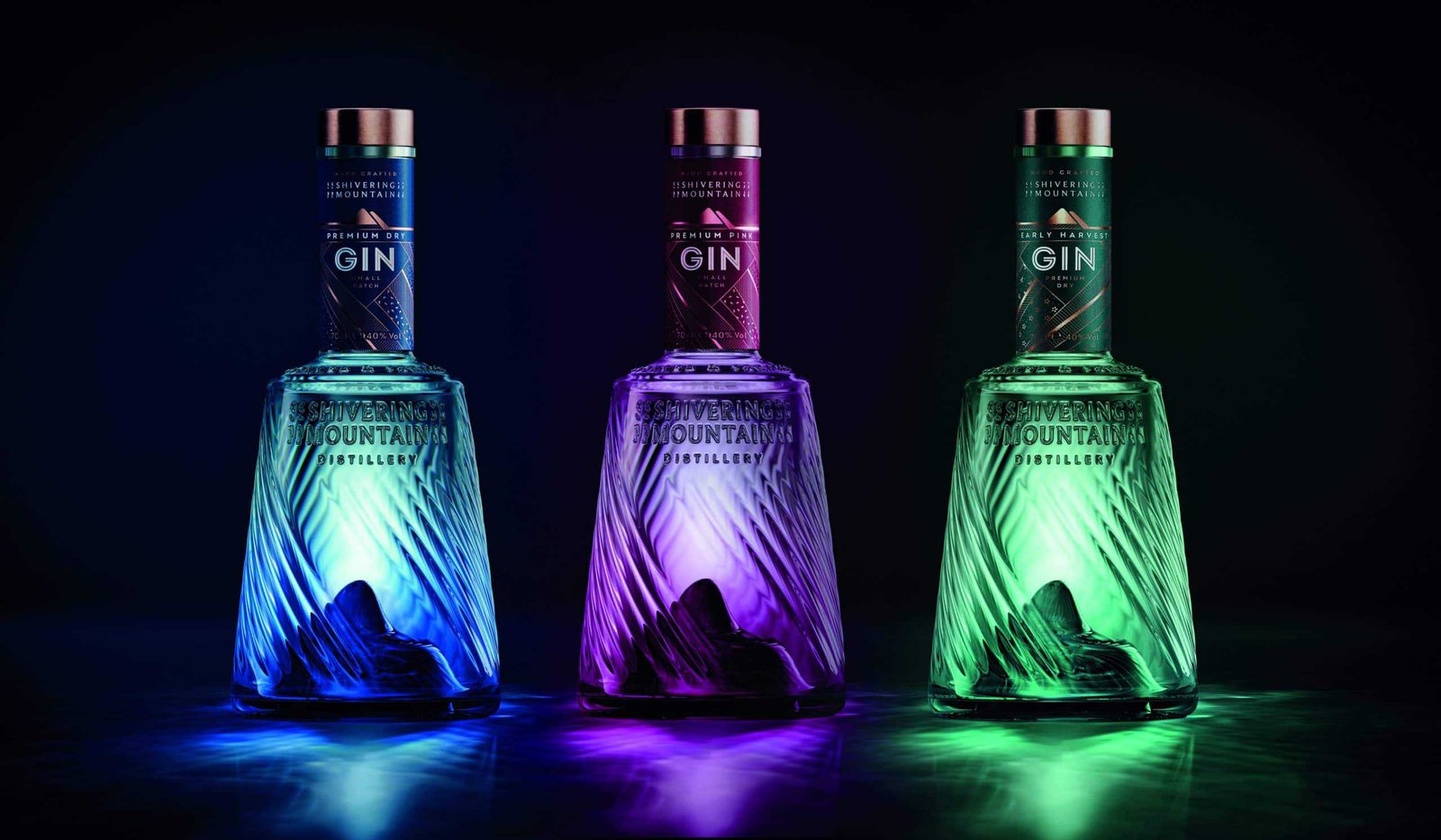 Three bottles of gin with peak colored lights on them, showcasing their perfection.