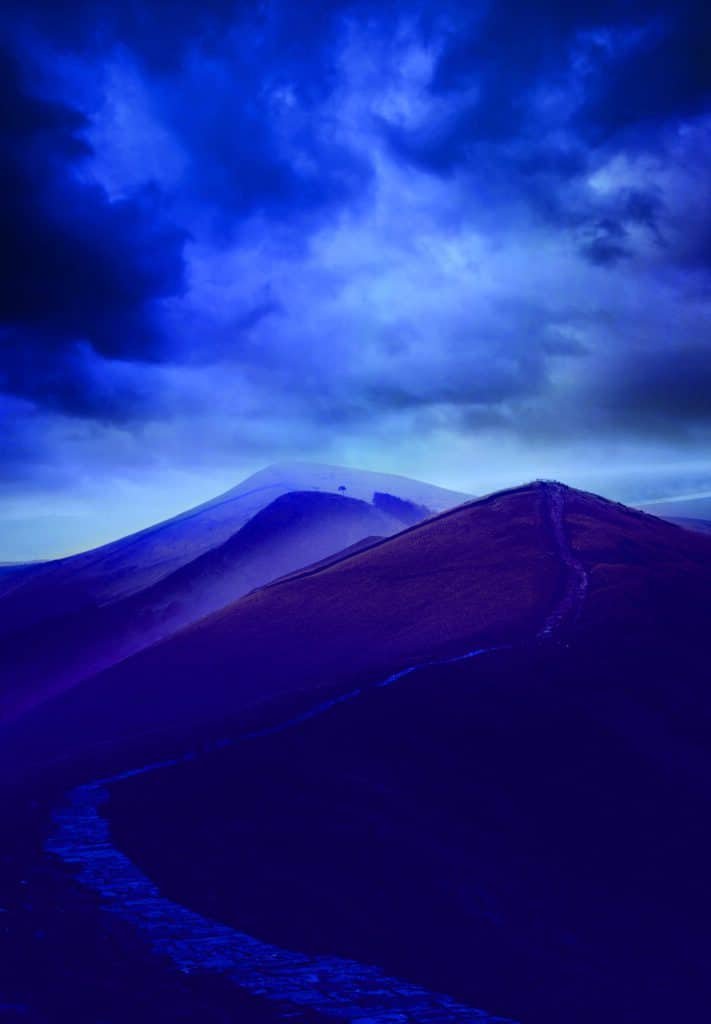 An image of a majestic mountain peak under a cloudy sky, portraying sheer perfection.