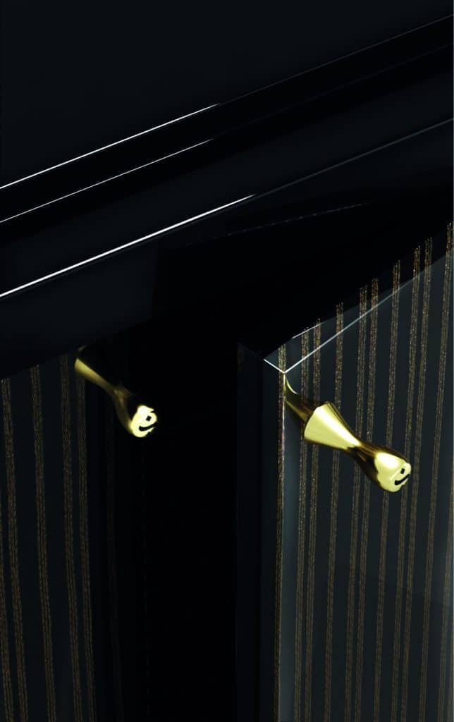 An important close-up of a black cabinet with glitters of gold handles.