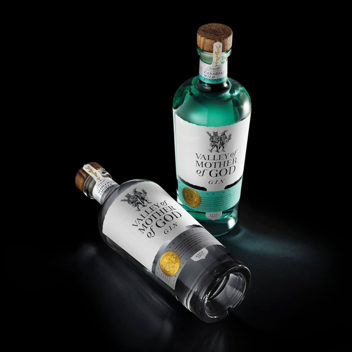 Two bottles of gin on a black background, connecting.