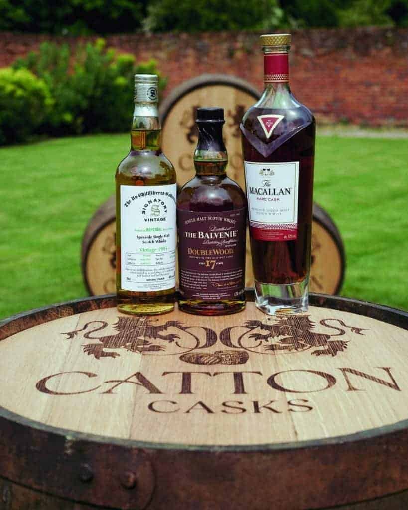 Three scotch whiskies on a barrel.