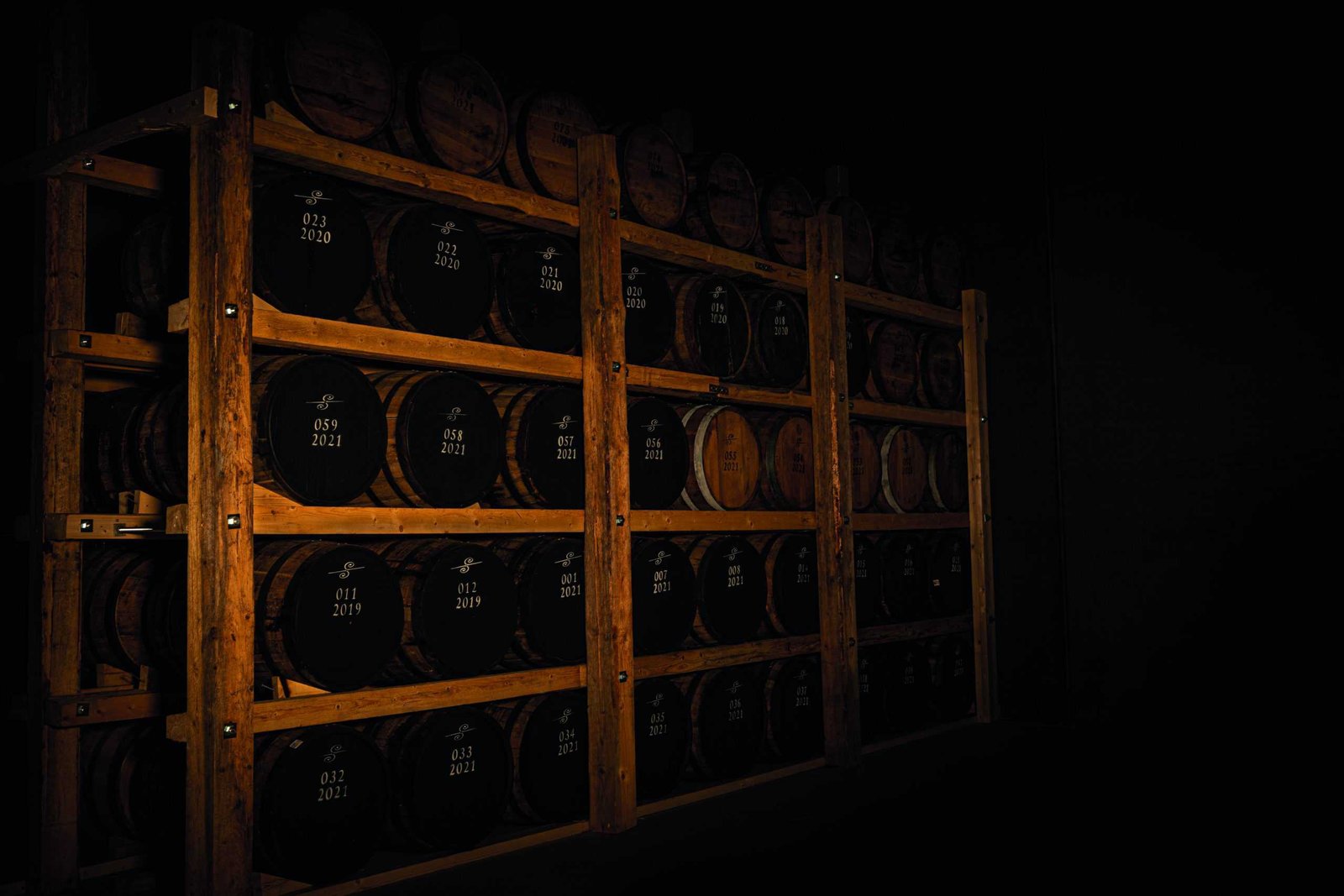 A Nordic-themed venture showcasing a rack of barrels in a dark room.