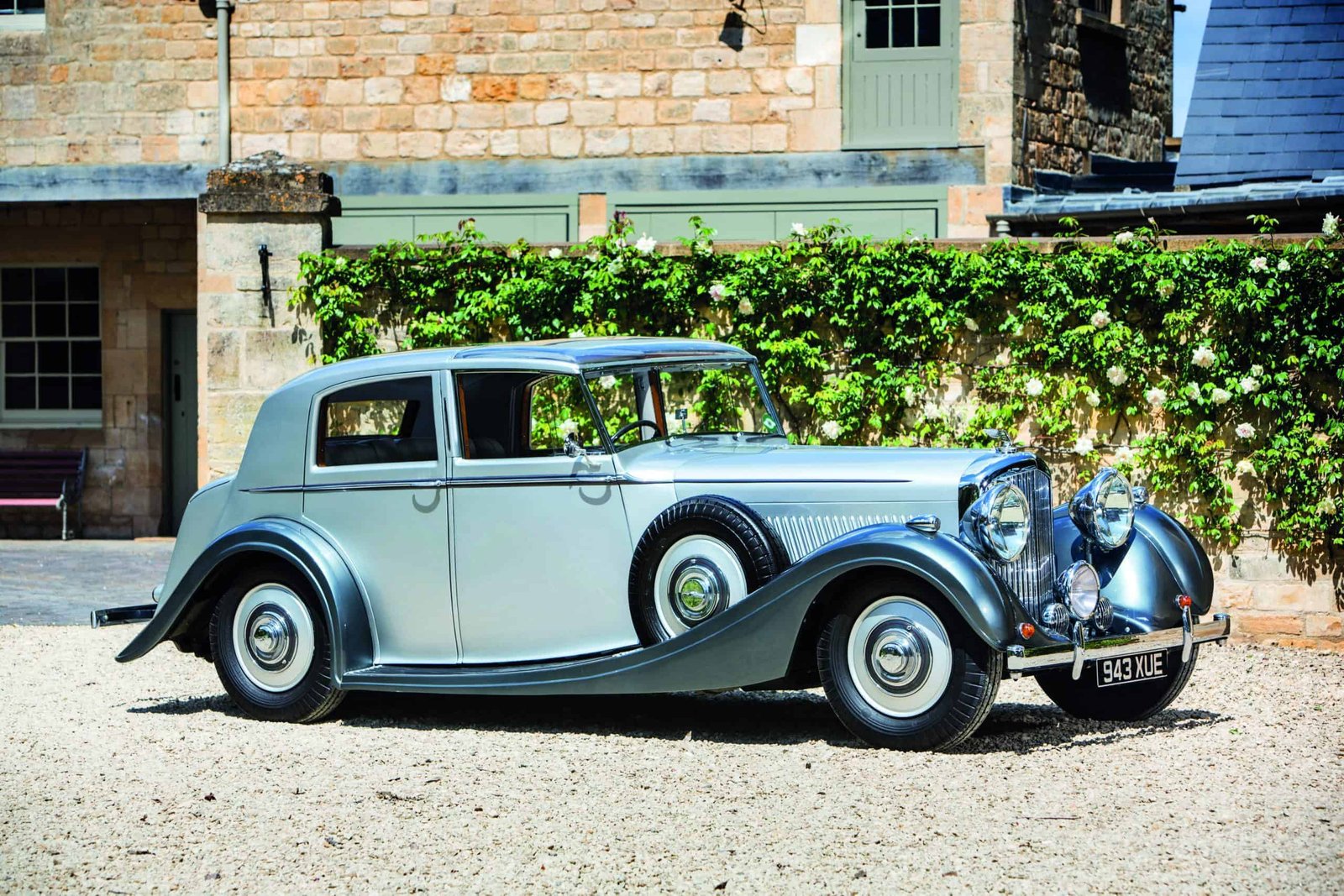 The best of both worlds - an old silver car parked in front of a building.
