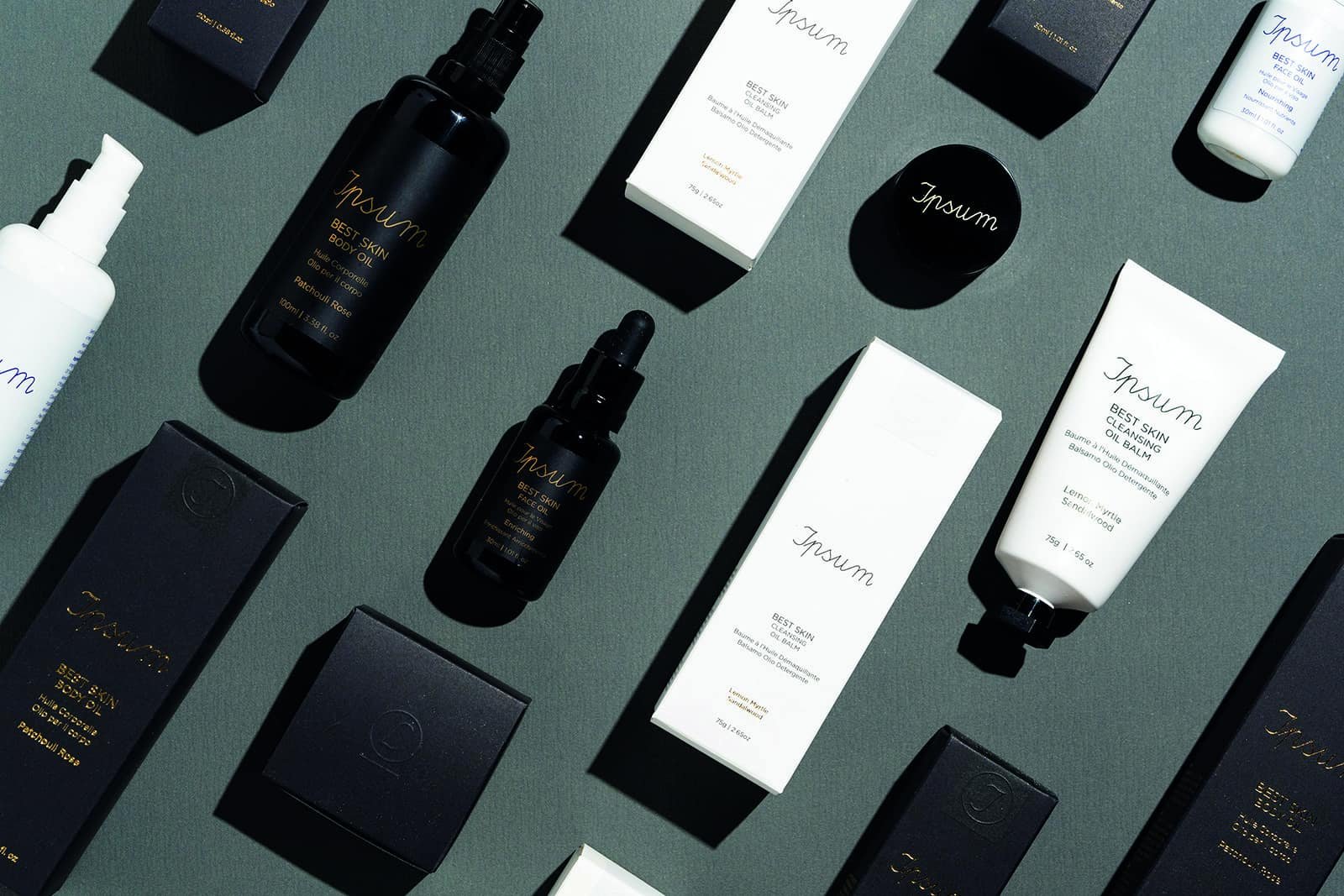 A collection of black and white cosmetic products on a table adorned with plants.