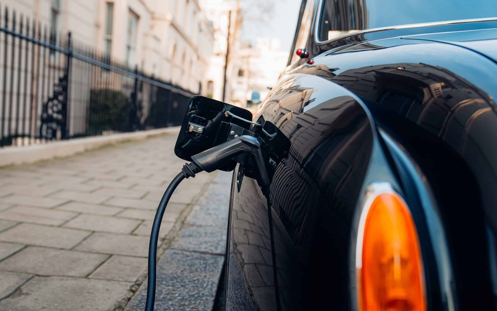 An old car is plugged into an electric charger.