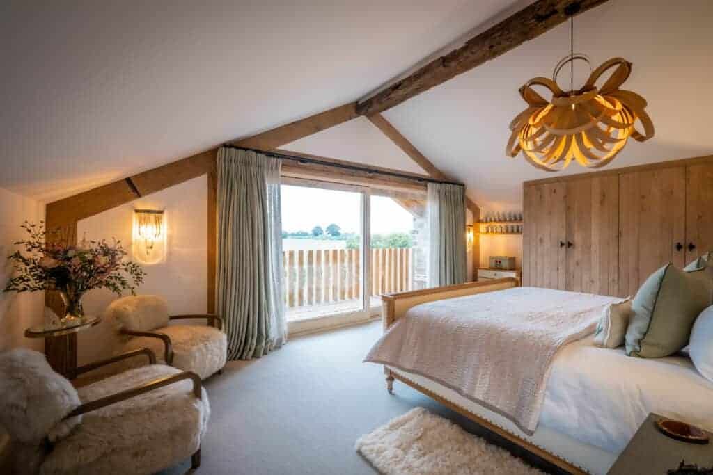 A homey bedroom with wooden beams and a large bed, embracing the warmth of nature.