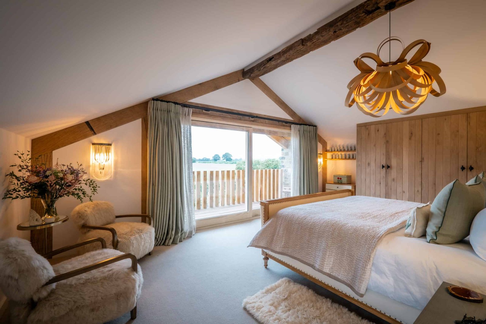 A homey bedroom with wooden beams and a large bed, embracing the warmth of nature.