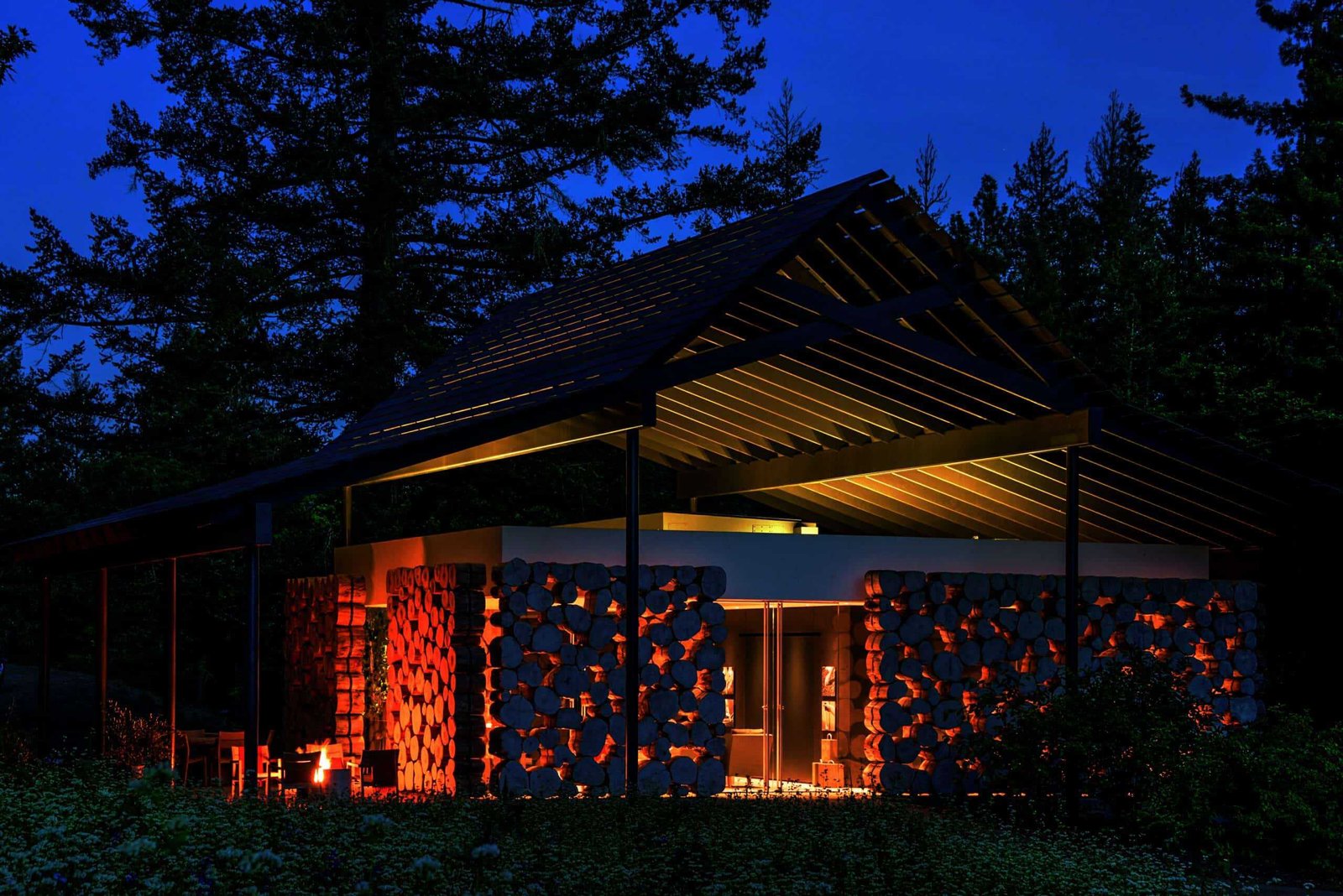 A cozy cabin in the woods illuminated at night, creating a captivating sense of place.