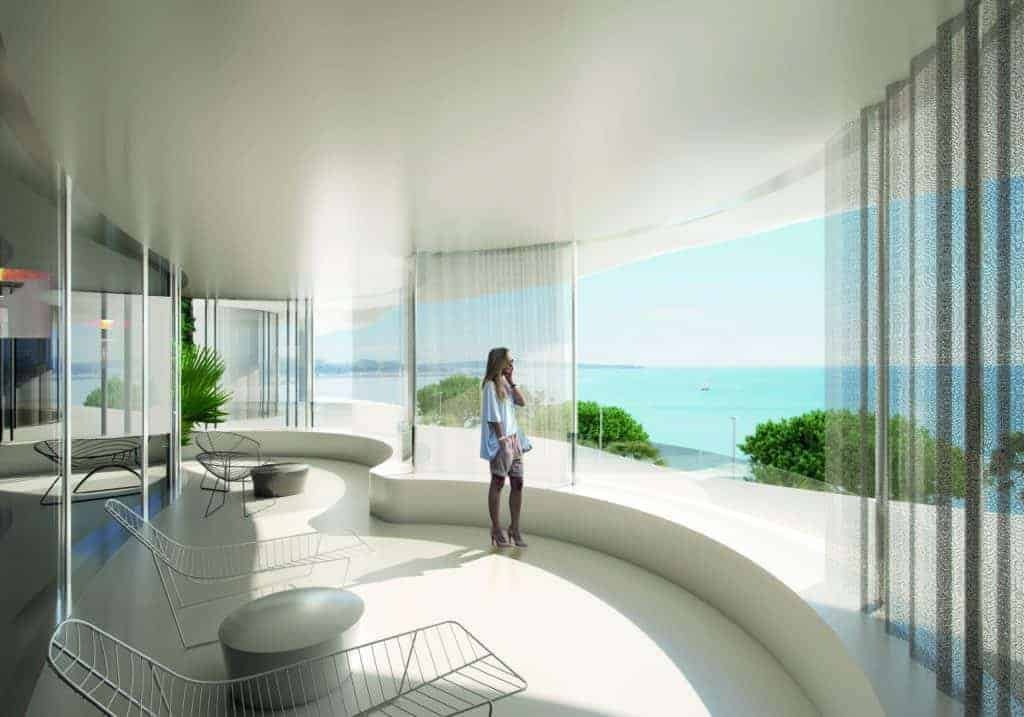A woman behold the breathtaking ocean view from a room.