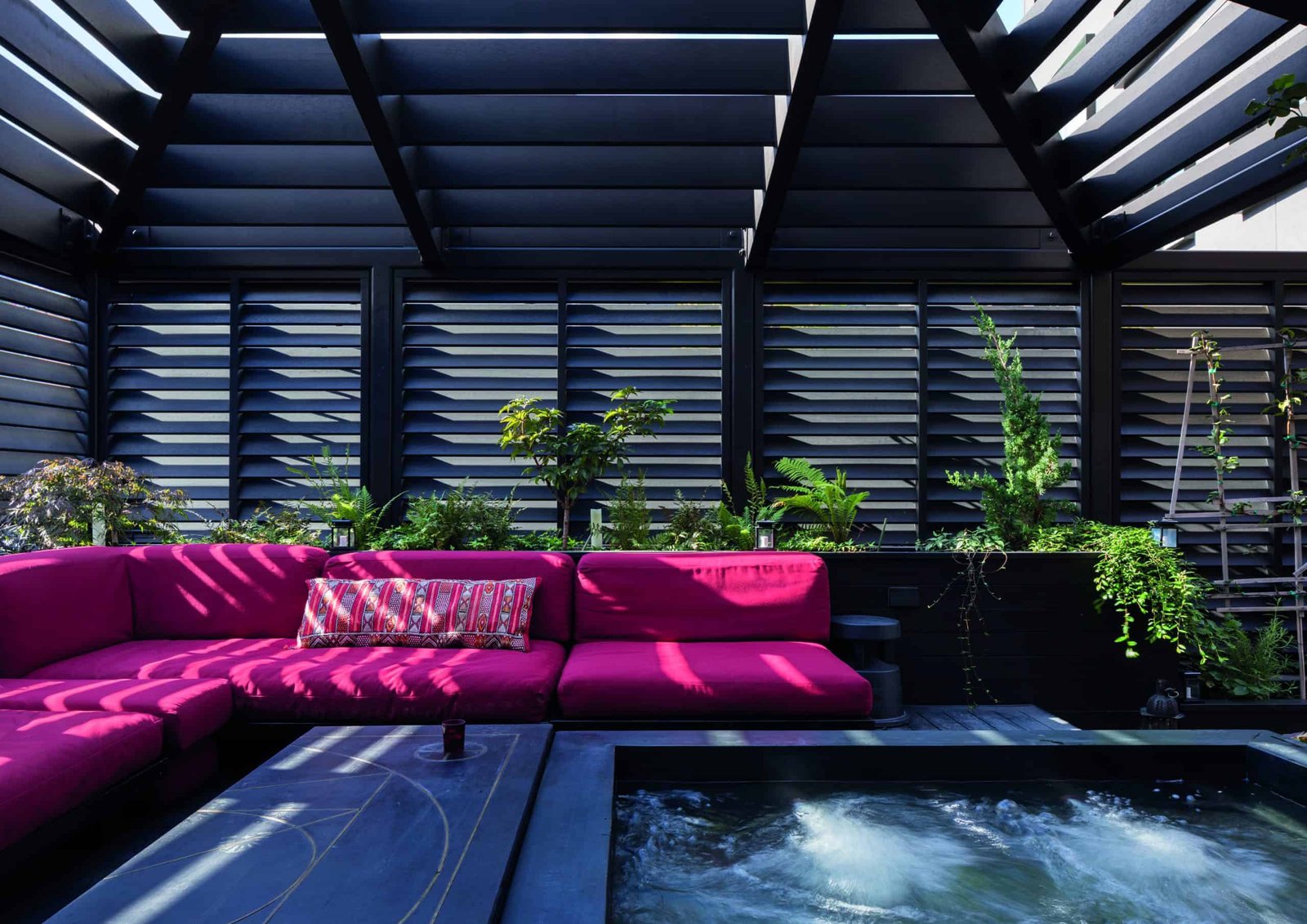 An eco-friendly backyard featuring a pink couch and a hot tub.