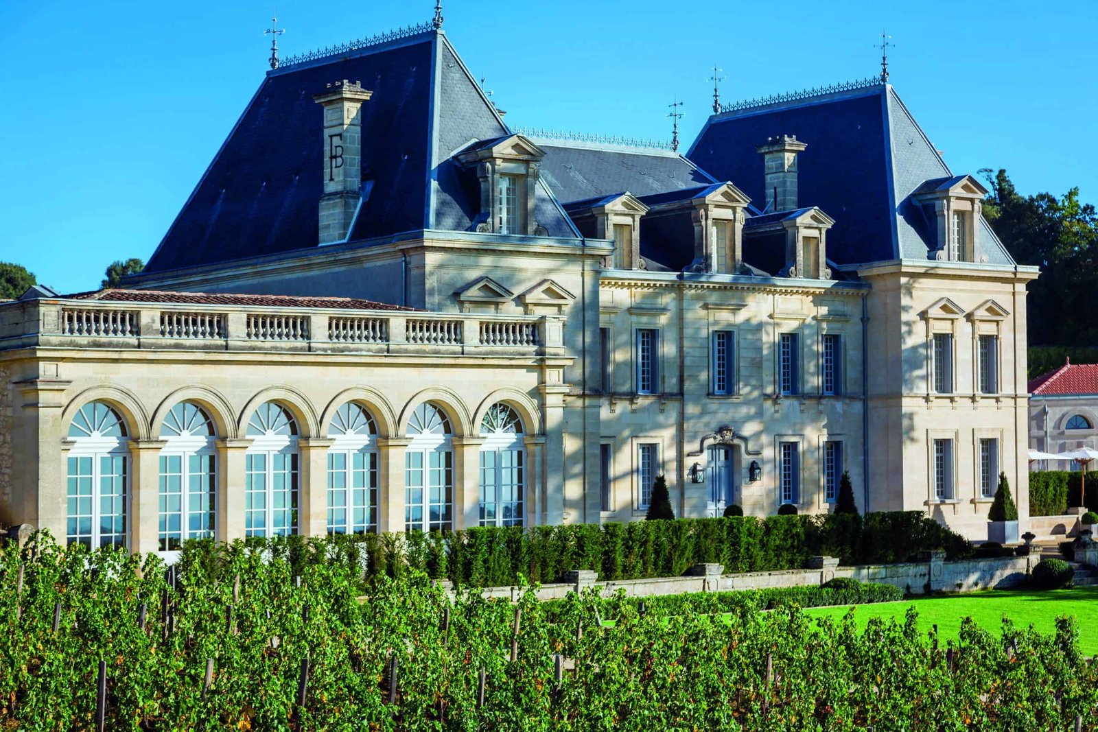 A grand mansion, exuding a captivating sense of place, majestically stands amidst the sprawling vineyard.