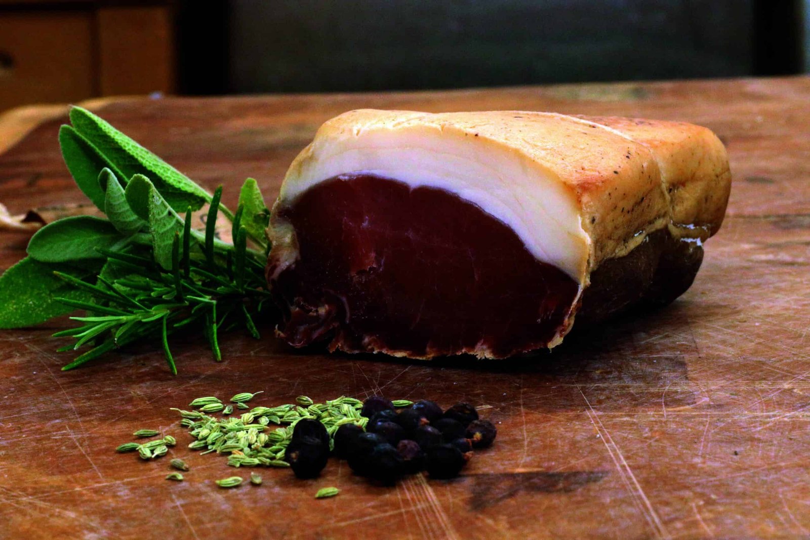 A piece of meat, perhaps a tail, is resting on a cutting board.